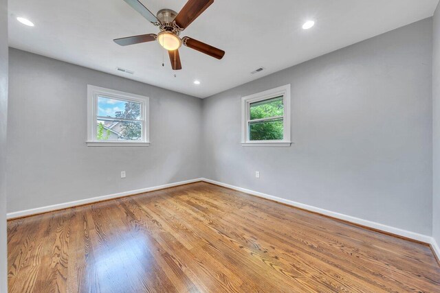 unfurnished room with visible vents, a ceiling fan, baseboards, and wood finished floors