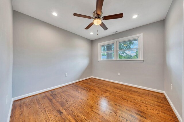 empty room with a ceiling fan, baseboards, and wood finished floors