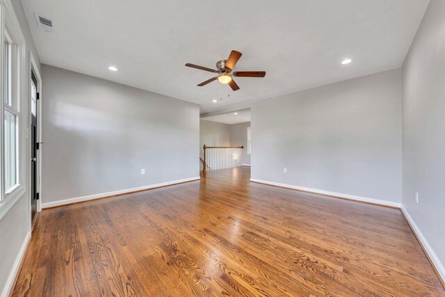 unfurnished room featuring visible vents, baseboards, ceiling fan, and wood finished floors