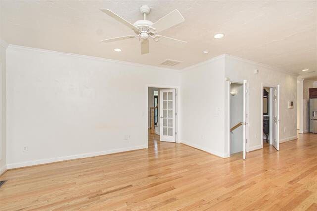 empty room with light hardwood / wood-style floors, ornamental molding, and ceiling fan