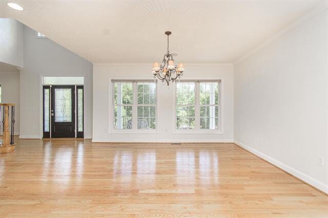 interior space with ornamental molding, a chandelier, and light wood-type flooring