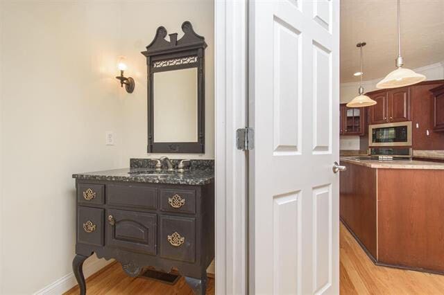 interior space with vanity and hardwood / wood-style flooring