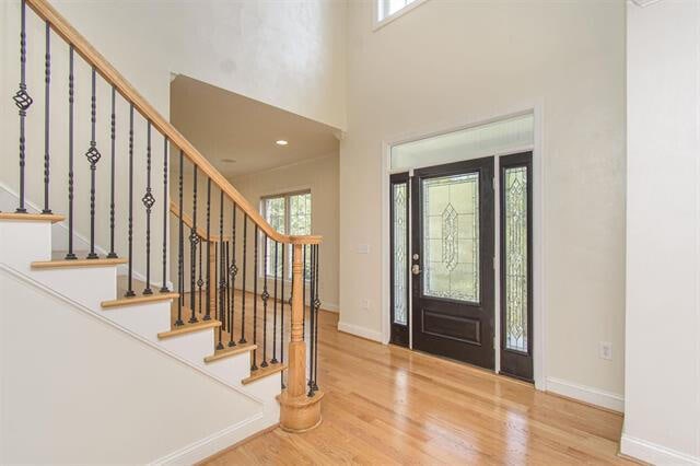 foyer featuring hardwood / wood-style flooring and a towering ceiling