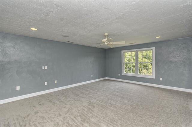 carpeted empty room featuring a textured ceiling and ceiling fan