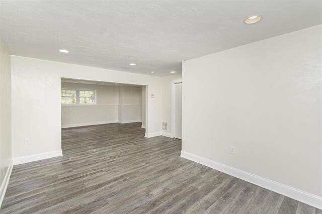 empty room with dark hardwood / wood-style flooring