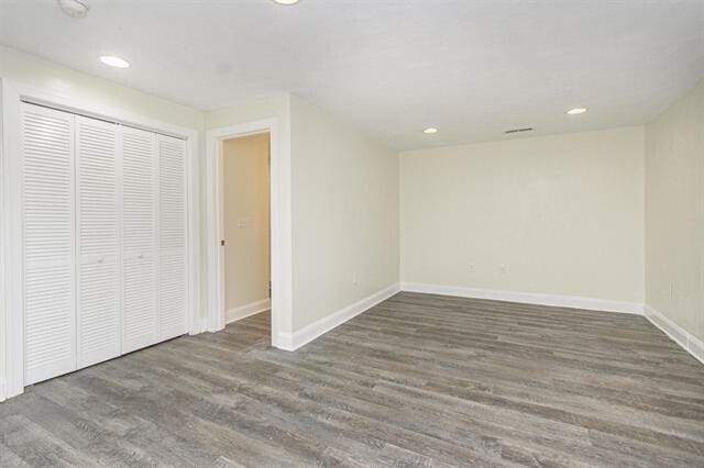 unfurnished bedroom with dark wood-type flooring and a closet