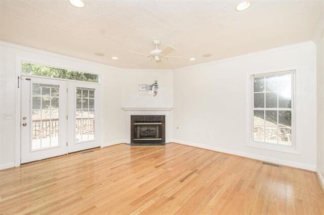 unfurnished living room with ornamental molding, light hardwood / wood-style floors, and ceiling fan