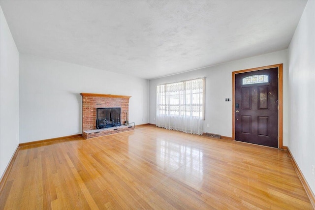 2422 Kingston Rd NW, Roanoke, VA 24017 - unfurnished living room featuring healthy amount of natural light, light wood-style floors, and a fireplace