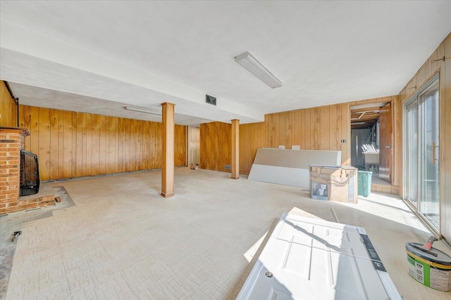 2422 Kingston Rd NW, Roanoke, VA 24017 - unfurnished living room with wood walls, light colored carpet, and a wood stove