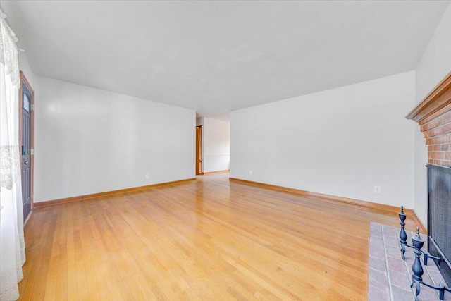 2422 Kingston Rd NW, Roanoke, VA 24017 - unfurnished living room featuring a brick fireplace and light wood-style floors