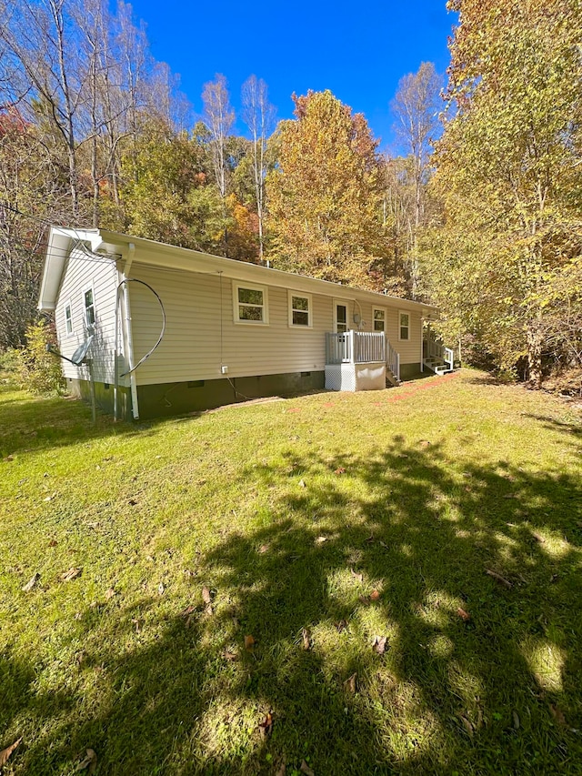 back of property with a lawn and a wooden deck