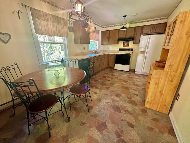 kitchen with sink, decorative light fixtures, and white appliances