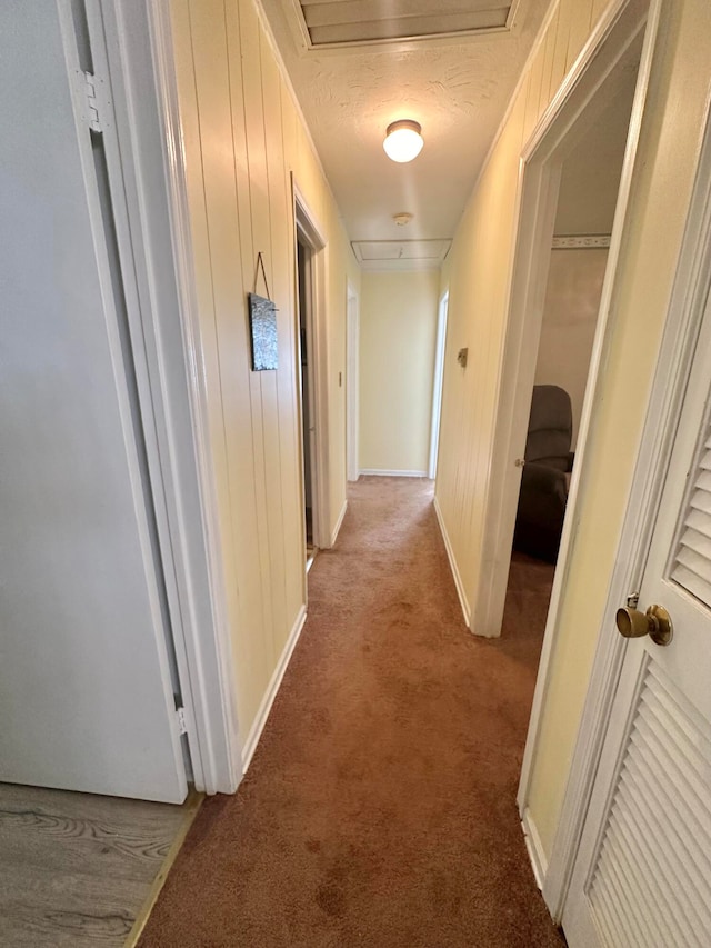 hall featuring a textured ceiling and light colored carpet