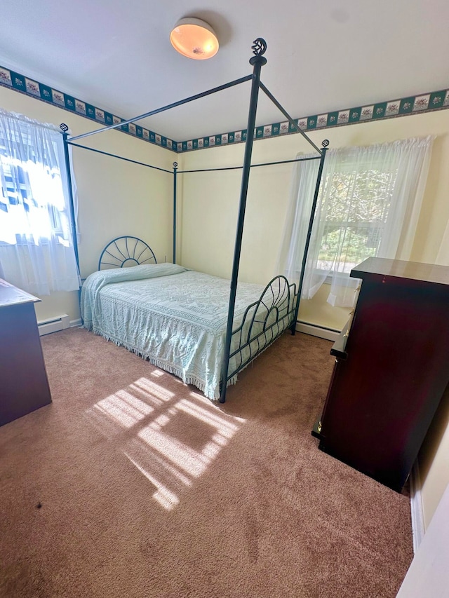 carpeted bedroom with a baseboard radiator and multiple windows