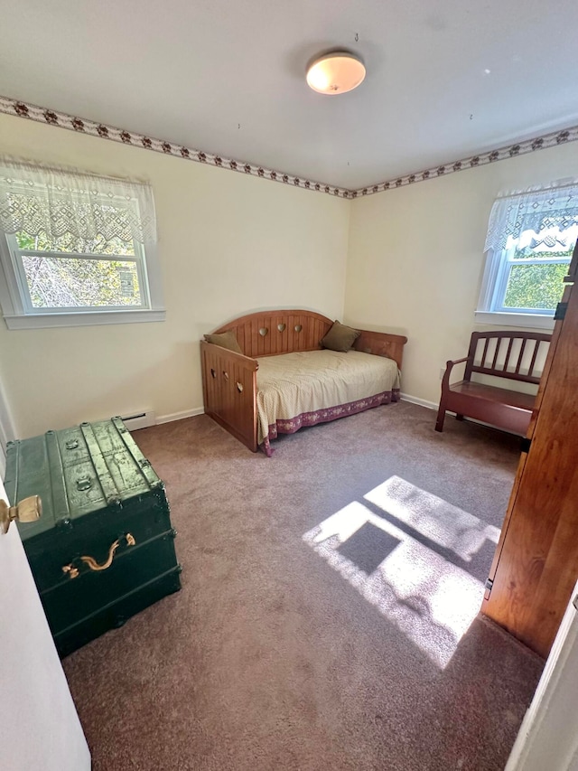 carpeted bedroom featuring multiple windows and a baseboard heating unit