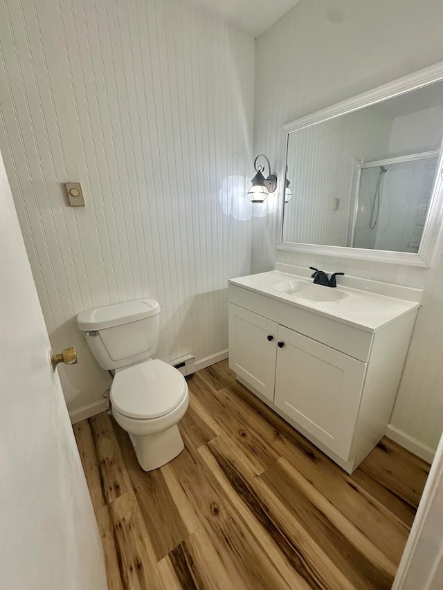 bathroom featuring vanity, baseboard heating, toilet, and hardwood / wood-style flooring