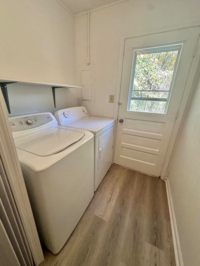 clothes washing area featuring independent washer and dryer and light hardwood / wood-style floors