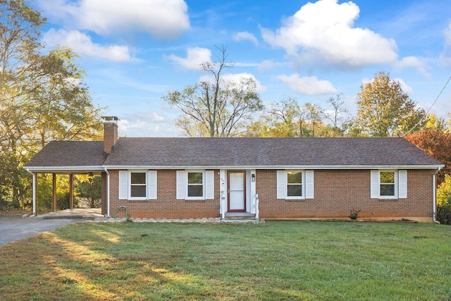 ranch-style home featuring a carport and a front lawn