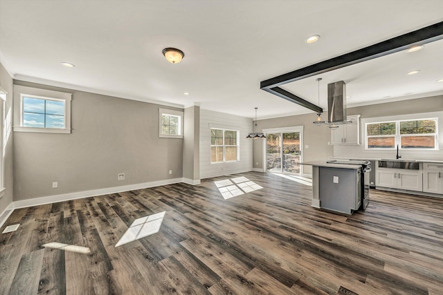 interior space featuring white cabinets, plenty of natural light, island range hood, and pendant lighting