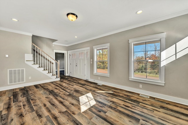 foyer featuring hardwood / wood-style floors, ornamental molding, and plenty of natural light