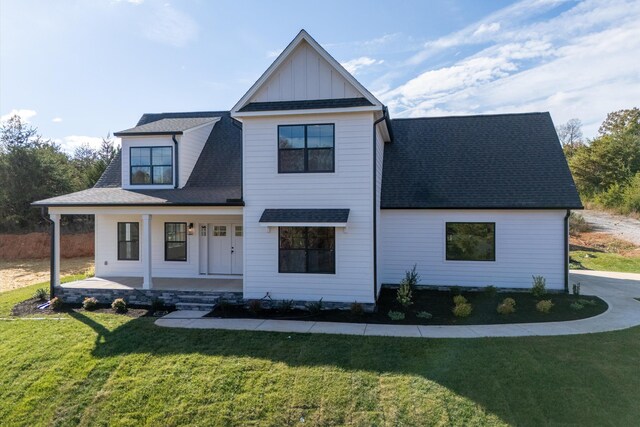 1154 Barrow Hills Dr, Huddleston, VA 24104 - modern farmhouse style home with a porch, roof with shingles, a front lawn, and board and batten siding