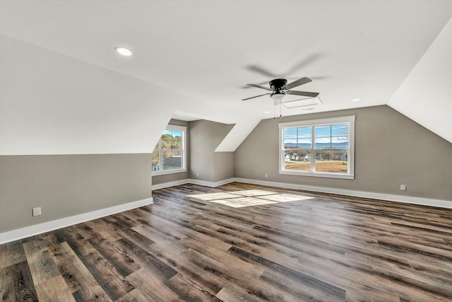 additional living space with dark hardwood / wood-style flooring, a wealth of natural light, lofted ceiling, and ceiling fan