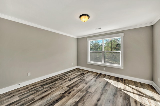 empty room featuring hardwood / wood-style floors and crown molding