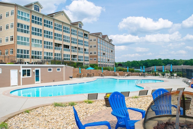 community pool with fence and a patio area