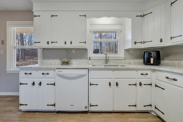 kitchen featuring sink, white dishwasher, a healthy amount of sunlight, and light wood-type flooring