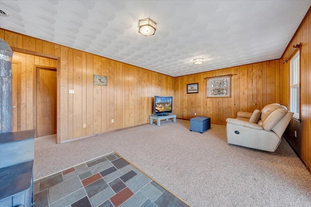 unfurnished living room with wooden walls and carpet