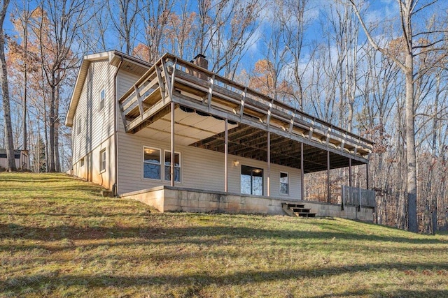 rear view of house featuring a yard and a wooden deck