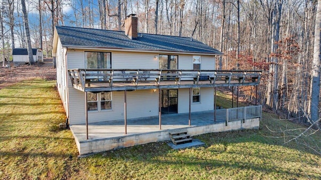 rear view of property featuring a patio area, a deck, and a yard