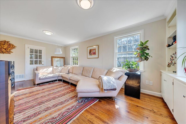 living room with plenty of natural light, light hardwood / wood-style floors, and crown molding