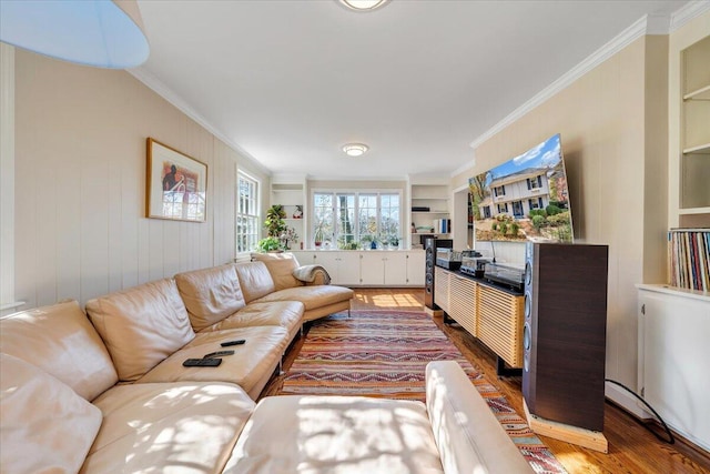 living room with built in shelves, wooden walls, hardwood / wood-style flooring, and crown molding