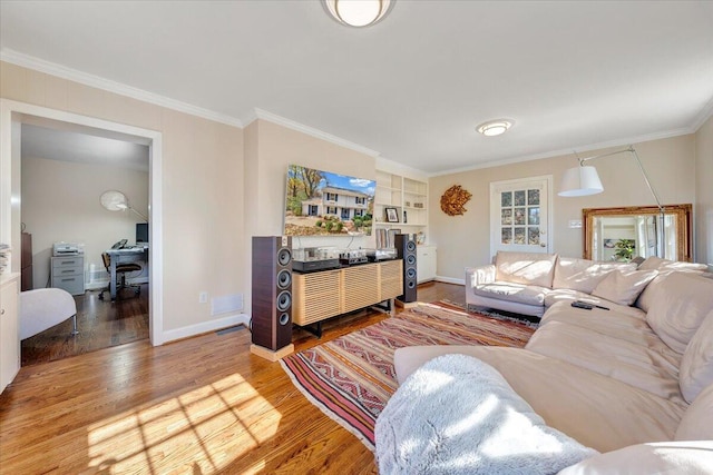 living room featuring hardwood / wood-style flooring, built in features, and ornamental molding