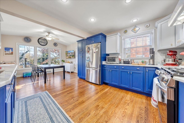 kitchen with white cabinets, stainless steel appliances, light hardwood / wood-style flooring, and blue cabinetry