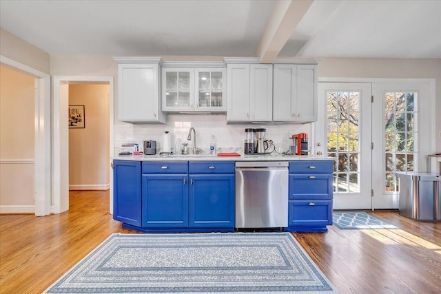 kitchen featuring stainless steel dishwasher, white cabinets, blue cabinets, and sink