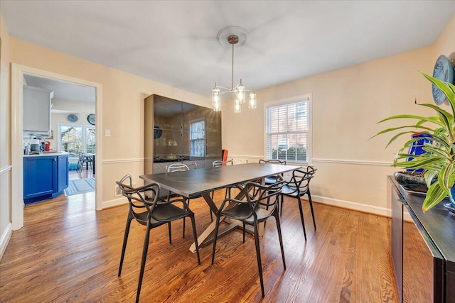 dining area featuring a notable chandelier, plenty of natural light, and light hardwood / wood-style flooring