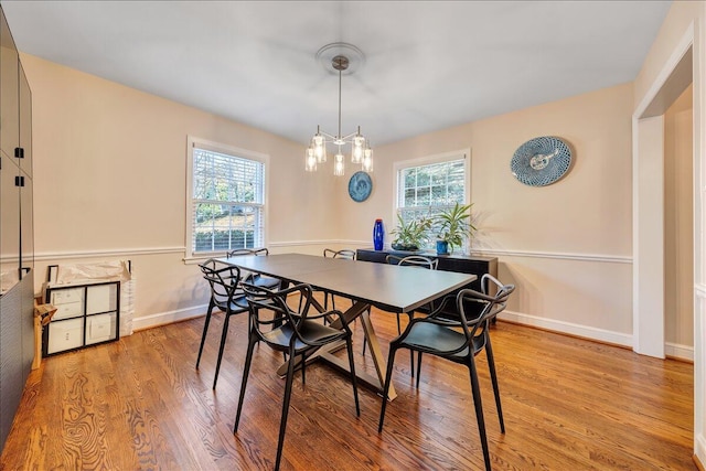 dining room featuring a notable chandelier, plenty of natural light, and light hardwood / wood-style flooring