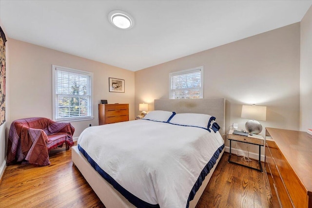 bedroom with multiple windows and hardwood / wood-style floors