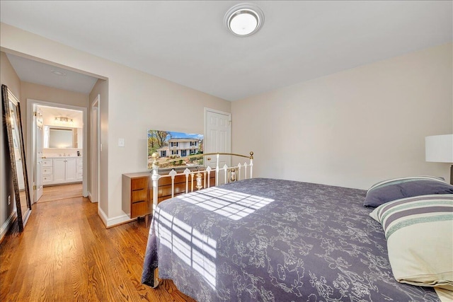 bedroom with hardwood / wood-style floors and ensuite bathroom