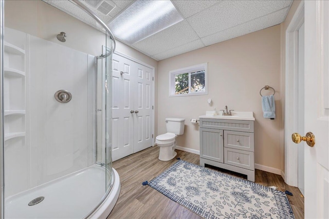 bathroom featuring a paneled ceiling, vanity, wood-type flooring, and a shower with door