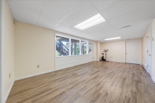 unfurnished room featuring a paneled ceiling and light hardwood / wood-style flooring