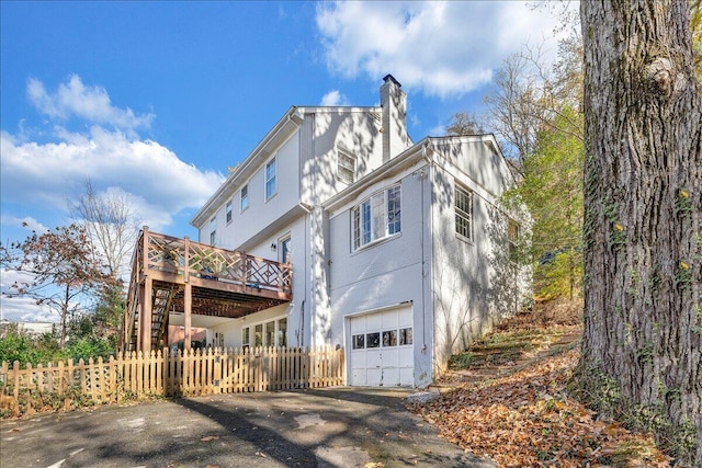 exterior space with a garage and a wooden deck