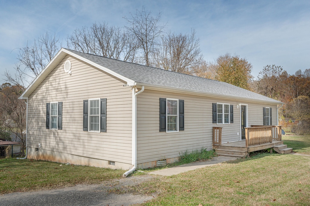 exterior space featuring a wooden deck and a front yard