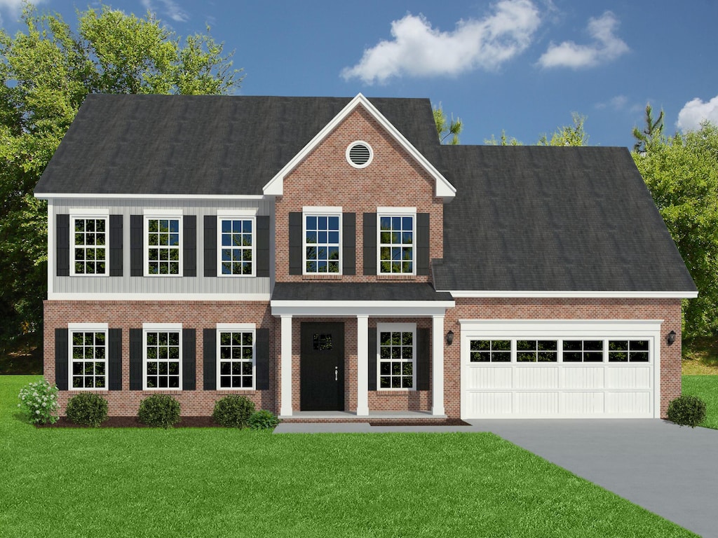 colonial-style house featuring a garage and a front lawn