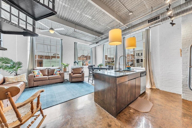 kitchen featuring dark brown cabinets, concrete flooring, plenty of natural light, and sink