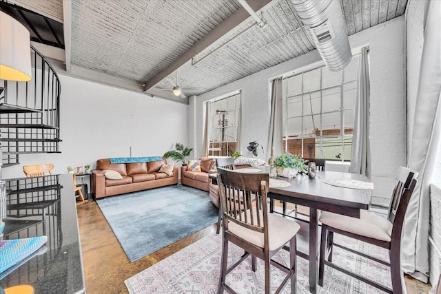 dining area with concrete flooring and beam ceiling