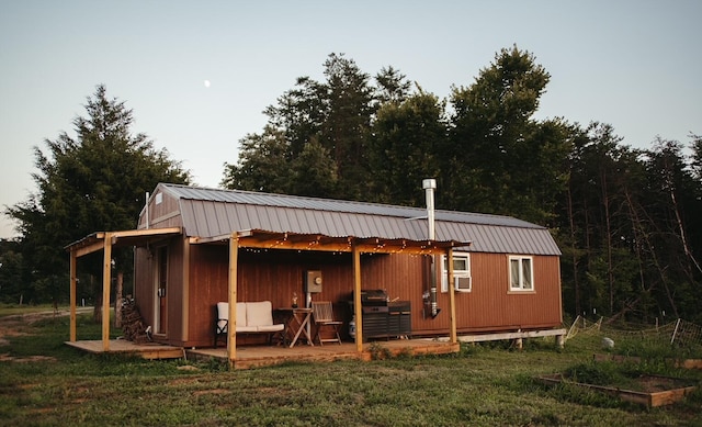 rear view of property featuring an outbuilding and a lawn