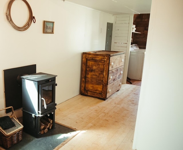 laundry area featuring electric panel, washer / clothes dryer, and wood-type flooring